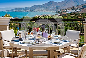 Table with fruits and wine on a summer terrace with sea and mountain views in Crete in Greece