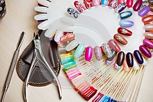 Table full of manicure utensils, manicure tools, nail polish colours on palette. Nails art accessories. Top view