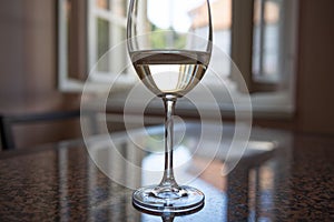 A table with glaas of vine and open window