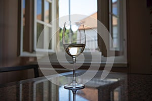 A table with glaas of vine and open window