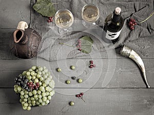 A bottle of wine, grapes and wine in a jug and glasses