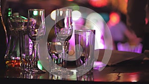 A table with glasses on the background of silhouettes of dancing people, the interior of the restaurant.