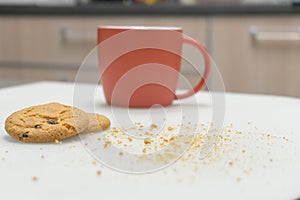 Table at home with Cup, chocolate cookies and crumbs, leisure lifestyle concept, soft focus photo