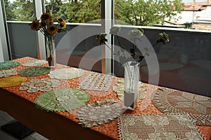 A table of homemade napkins and flowers in a vase