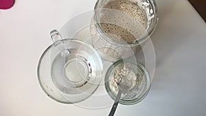 On the table are the ingredients for the preparation of bread sourdough. Flour, water and cooked mixture that began to ferment.