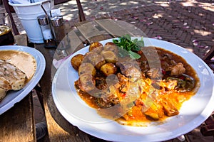 Table with lamb meat in vegetable sauce and potato