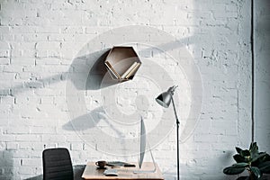 table lamp, computer and shelf on wall