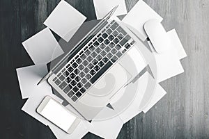 Table with laptop and paper sheets