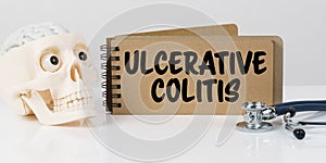 On the table lies a skull, a stethoscope and a notebook with the inscription - ULCERATIVE COLITIS