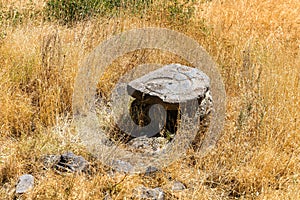 Table made of ancient stones among the autumn grass in the mountains.