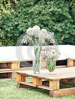 Table made with wooden pallets decorated with a vase with flowers