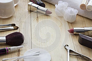 Table with makeup , brushes, lipstick and cream