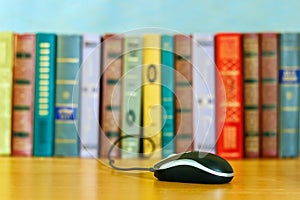 On the table a number of books and a mouse from the laptop.