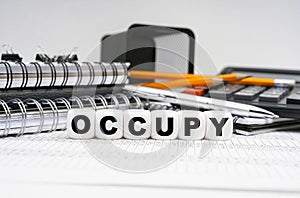 On the table, among office objects, cubes with the inscription - OCCUPY