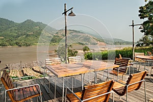 Table in outdoor with Green Mountain and river Background