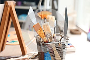 Table with paint tools in artist's workshop