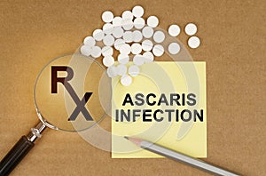 On the table are pills, a magnifying glass, pencils and a sticker with the inscription - Ascaris Infection