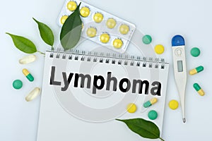 On the table are pills, a thermometer, leaves and a notebook with the inscription -Lymphoma