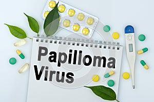 On the table are pills, a thermometer, leaves and a notebook with the inscription -Papilloma Virus