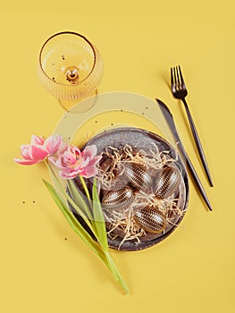 Table place setting, empty glass, Pink tulips and festive easter decor