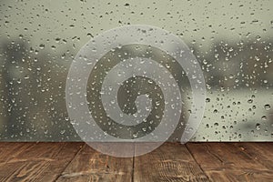 Table on rainy window background