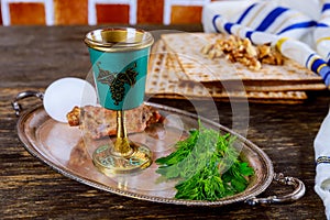 Table ready for traditional seder plate ritual the Jewish holiday of Passover. Kiddush cup, haggada, matzos, lettuce