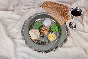 Table ready for traditional seder plate ritual the Jewish holiday of Passover. Kiddush cup, haggada, matzos, lettuce