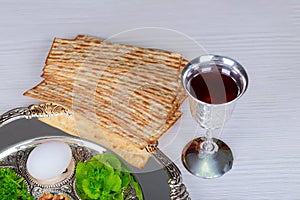 Table ready for traditional seder plate ritual the Jewish holiday of Passover. Kiddush cup, haggada, matzos, lettuce