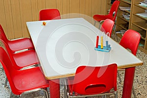 Table with red chairs of a school class for children