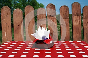 A table with a red cloth on a background of wooden fence