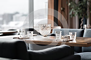 Table in restaurant served for lunch. Glasses, flower fork, knife served for dinner in restaurant with cozy interior