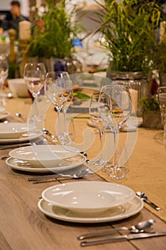 Table in the restaurant served for several persons with glasses and plates