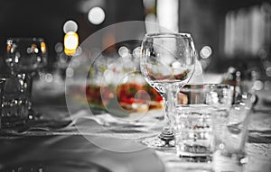 Table in restaurant with white tablecloth and empty glasses