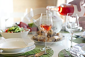 Table with rose wine, fish soup, salad and chiken