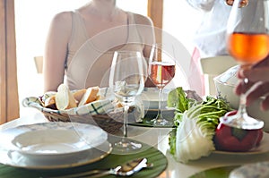 Table with rose wine, fish soup, salad and chiken