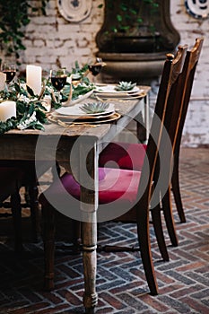 A table scape designed for a boho style event with an eucalyptus garland and succulents and other rustic touches as well as