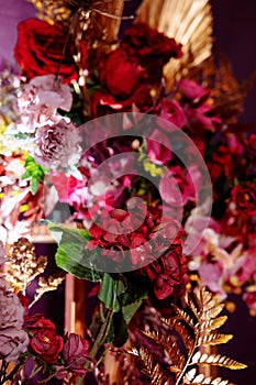 Table served for Christmas dinner, festive setting with decorations, burning candles and golden fern branches, glasses. Selected