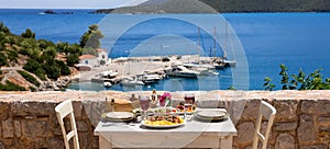 A table served for two with chicken souvlaki and french fries, greek salad, snacks and drinks on the summer terrace of the hotel r