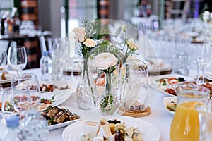 Table set for an event party or wedding reception. There is a lot of varied food on the table, luxury catering.