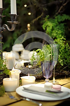 Table set for an event party or wedding reception in rustic or scandinavian style decorated moss and fern. Fashionable table set