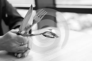 Table set fork, spoon, knife in women`s hands on the table.