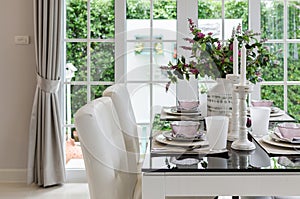 Table set on glass dinning table with white chairs