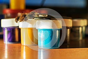 On the table is a set of gouaches in jars and brushes