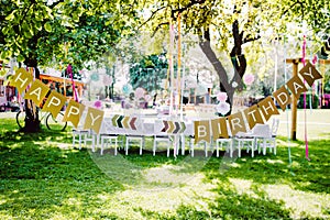 A table set for kids birthday party outdoors in garden in summer.