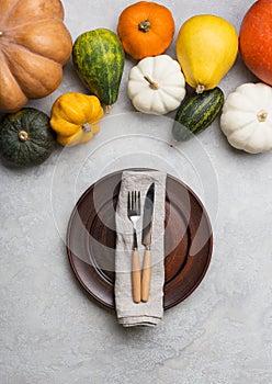 Table set with pumpkins, empty plate and knife and fork