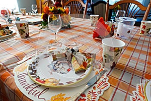 Table set for thanksgiving dinner with decorative paper plates, napkins and cups