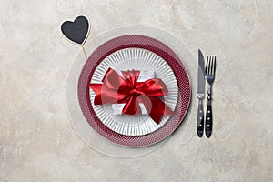 Table set for Valentine`s day dinner with gift and table wear