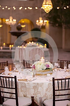 Table settiings for a large wedding ceremony in an outdoor patio area