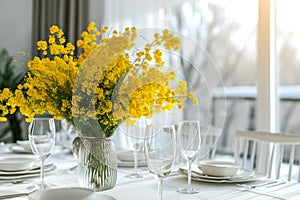 table setting. Bouquet of mimosa in a vase, plates and cutlery on a light table.