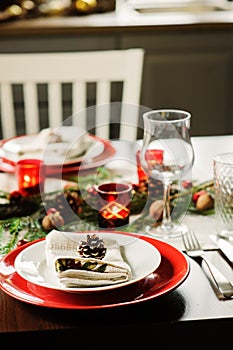 Table setting for celebration Christmas and New Year Holidays. Festive table in classic red and green at home with rustic details